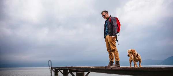 Man Standing Wooden Dock Stormy Weather His Dog Wearing Red — Stock Photo, Image