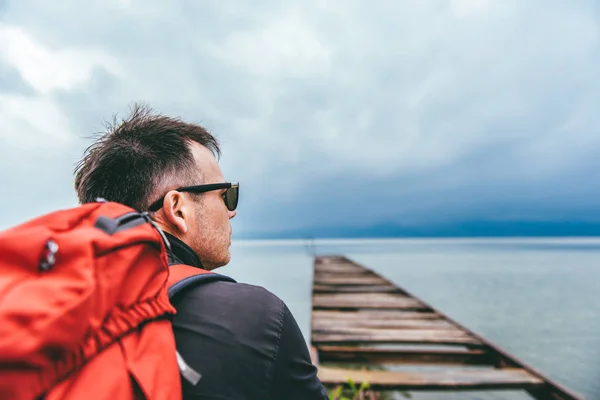 Man standing on a river dock and looking sideways