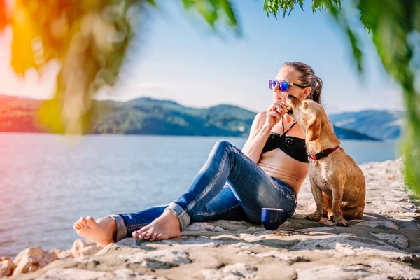 Kvinde Med Solbriller Iført Sort Bikini Jeans Giver Hendes Hund - Stock-foto