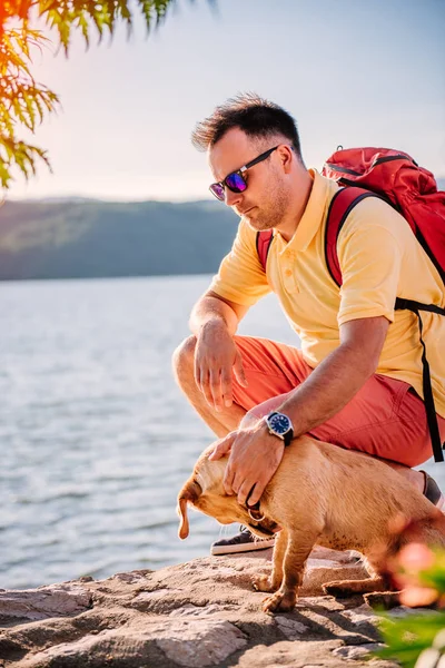 Hombre Camisa Amarilla Gafas Sol Mochila Roja Cuclillas Junto Mar — Foto de Stock