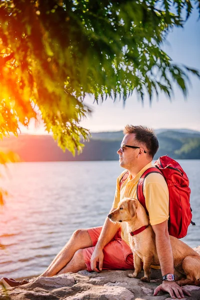 Man Yellow Shirt Sunglasses Red Backpack Sitting Stone Dock Sea — Stock Photo, Image