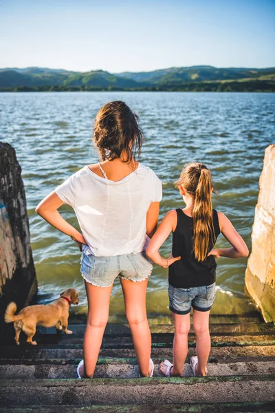 Dos Chicas Perro Pie Muelle Con Las Manos Las Caderas — Foto de Stock