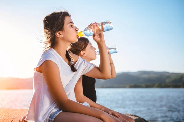 Dos Chicas Sentadas Junto Mar Bebiendo Agua Una Botella Pet — Foto de Stock