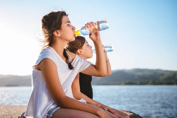 Dos Chicas Sentadas Junto Mar Bebiendo Agua Una Botella Pet — Foto de Stock