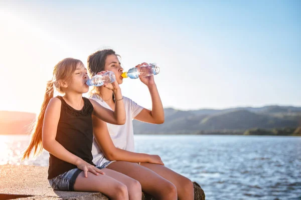 Dos Chicas Sentadas Junto Mar Bebiendo Agua Una Botella Pet — Foto de Stock