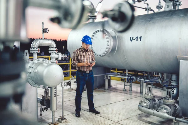 Tablet Doğalgaz tesis işleme kullanarak mavi kask giyen adam