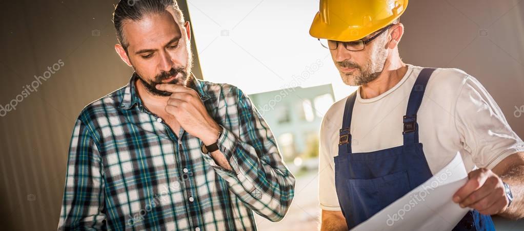 Architect and Construction workers checking checking Architectural plan in construction site