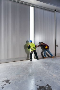 İnşaat İşçileri büyük hangar kapısını açma