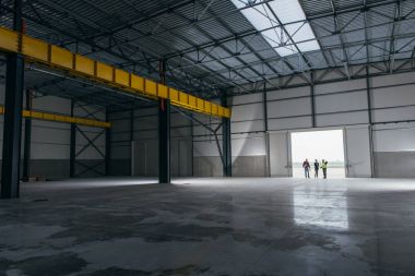 Takım, İş Makinası ile planları ayakta büyük hangar kapıları, mimar