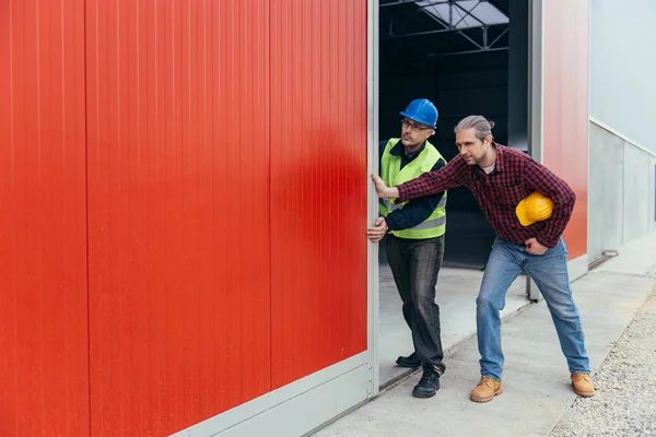 Construction Workers Opening Big Red Hangar Door — Stock Photo, Image