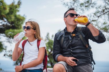 Baba ve kızı uzun bir yürüyüşten sonra dinleniyor.
