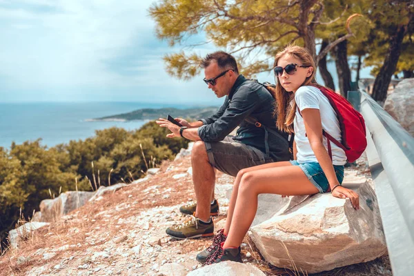 Father and daughter sitting on a rock after hiking — Stock Photo, Image