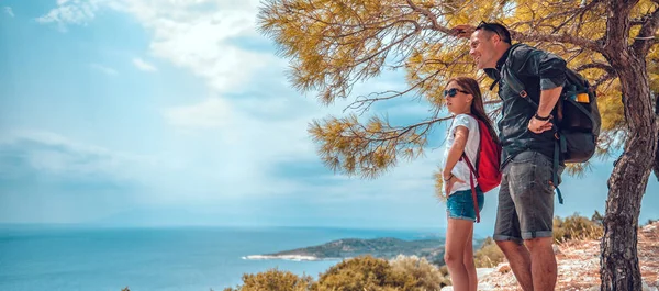 Father and daughter standing on a cliff by the sea — Stock Photo, Image