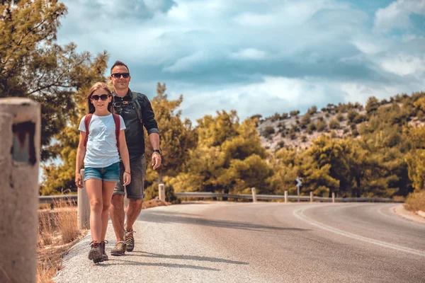 Father and daughter hiking on the mountain road — Stock Photo, Image