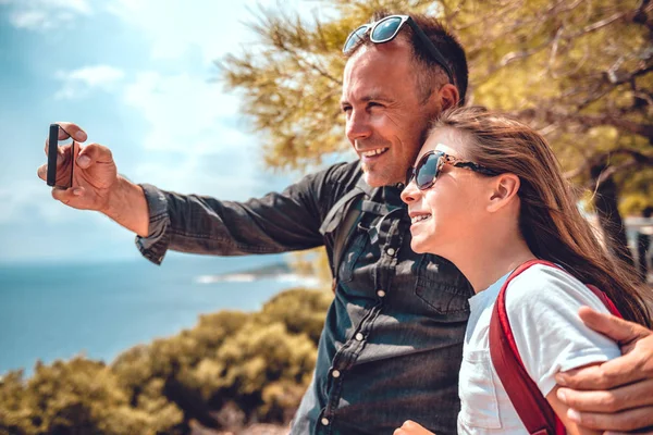 Padre e hija haciendo selfie con teléfono inteligente Fotos De Stock