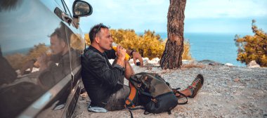 Arabada dinlenen ve portakal suyu içen adamlar.