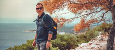 Bir deniz yamacında yürüyüşçü.