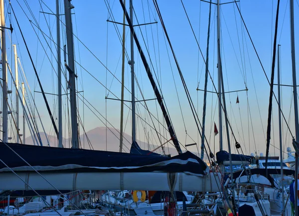 Naples, balıkçı köyü Ovo kalenin teknelerin ağaçları arasında gün batımında Vesuvius.