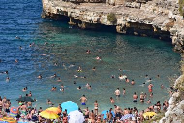 İtalya, Puglia bölge, 18/08/2017, Polignano, turistler denizin Lama Monachile Bay gidin.
