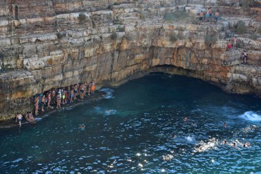 İtalya, Puglia bölgesi, 18/08/2017, Polignano, Lama Monachile Körfezi 'nde denizde turistler.