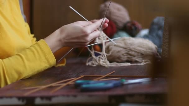 Primo piano medio di mani di donna su un tavolo di legno lavora a maglia uno snood con filato alla panna — Video Stock
