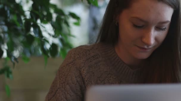 Посередині крупним планом з красивою дівчиною, що працює на ноутбуці на терасі саду — стокове відео