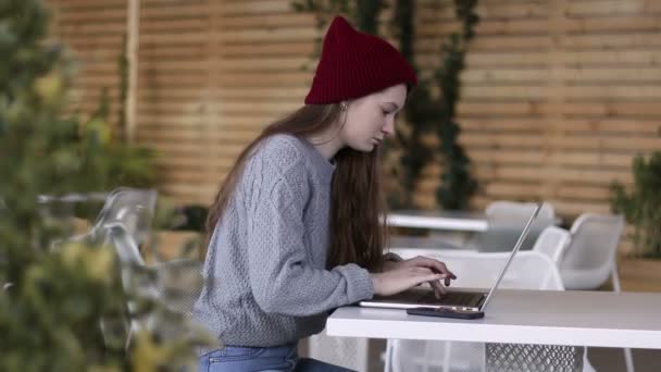 Middellange schot van jonge mooie tiener laptop op het terras in de tuin werken — Stockvideo