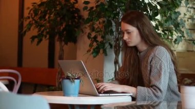 Güzel kız çalışma ve sohbet laptop kahve bahçesinde orta çekim