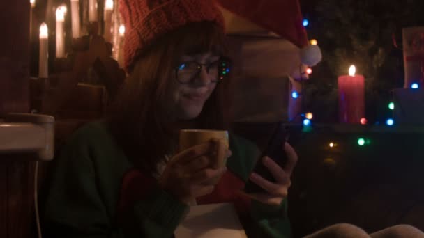 Yong femme boire du thé prendre selfie et sourire à la maison de Noël atmosphère confortable — Video