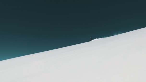 Μακρινό σουτ του ο σκιέρ κατεβαίνει στην ακραία καλυμμένα με χιόνι πλαγιά — Αρχείο Βίντεο