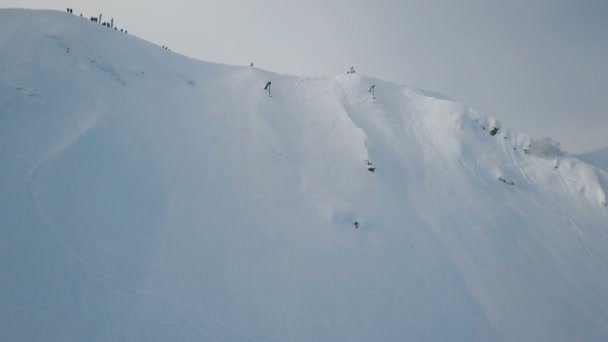 空中拍摄的滑雪者下降在极端积雪覆盖的山顶上 — 图库视频影像