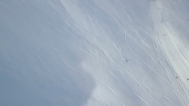 Повітряний постріл лижника спускається на крайній засніженій вершині гори — стокове відео