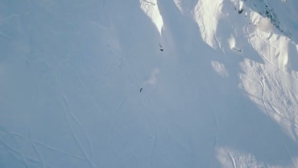 Aerial shot of the skier descends on extreme snow-covered top of the mountain — Stock Video