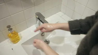 Sokaktan döndükten sonra el yıkayan bir kadın resmi.