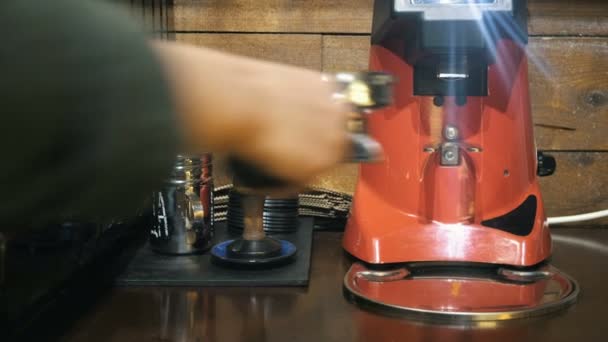 Medium close up of barista hand inserts a holder into a coffee grinder — Stock Video