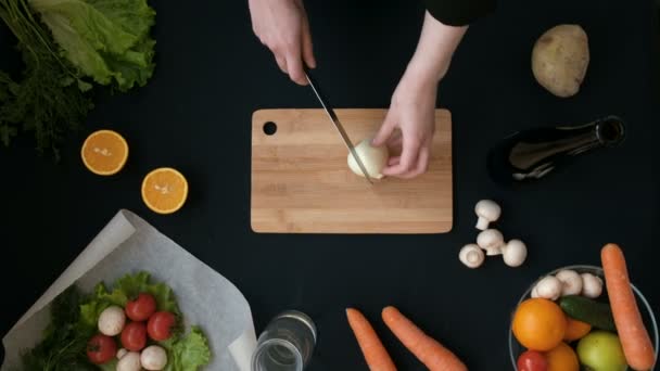 Pemandangan utama tangan wanita memotong sayuran di papan kayu di dapur — Stok Video