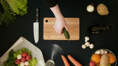 Tahta tahtada taze sebze kesen genç bir kadının en iyi görüntüsü. 