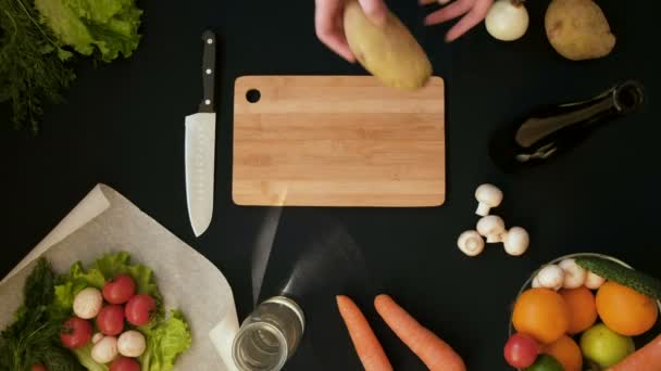 Vista superior mango disparo de mujer joven corte de verduras frescas en tablero de madera — Vídeo de stock