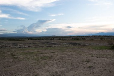 Los Hoyos 'un günbatımı çimlerle, kumullarla, bulutlarla ve mavi gökyüzüyle Tatacoa Çölü, Huila, Kolombiya. 