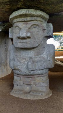 Kolombiya San Agustin arkeoloji parkındaki bir dolmen mezarına ellerinde kalemle kadim bir katip heykeli. Antik kolomb öncesi kültür.