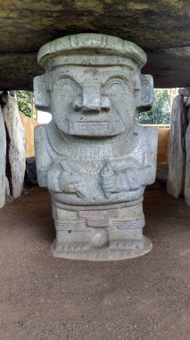 Kolombiya San Agustin arkeoloji parkındaki bir dolmen mezarına ellerinde kalemle kadim bir katip heykeli. Antik kolomb öncesi kültür.