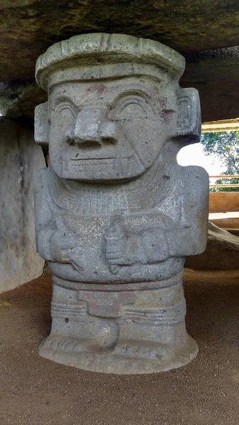 Kolombiya San Agustin arkeoloji parkındaki bir dolmen mezarına ellerinde kalemle kadim bir katip heykeli. Antik kolomb öncesi kültür.