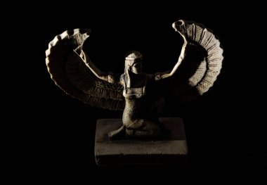 Isis 'e yakın. Eski kanatlı dişi Mısırlı tanrı figürü. Siyah arka planda beyaz ışıklarla aydınlatılmış.