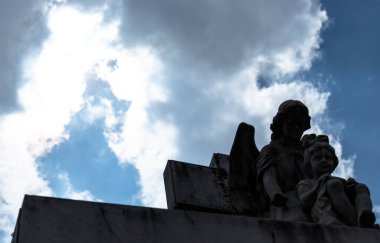 Melek ve çocuk heykeli, anıt mezarlığın tepesine alçak açıyla bakıyor. Gizemli fotoğrafçılık