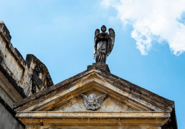 Bir melek ve bir melek şehir merkezindeki eski ve tanıdık bir mozolenin ön cephesini dekore ediyor.
