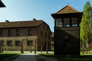 Nazi Auschwitz toplama kampında barakanın yanında gözetleme kulesi ve çift elektrikli dikenli tel.