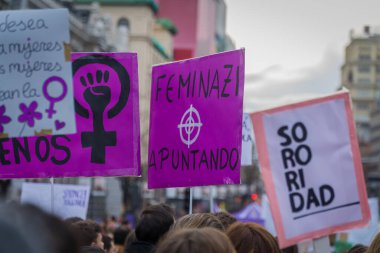 Uluslararası Kadınlar Günü 'nde 8 M yürüyüşü sırasında kalabalığın ortasında haklarını iddia ederek ilginç mor ve beyaz protesto işaretleri