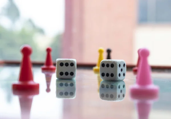 Closeup to a double six old dices with color pawns over a Colombian native board game named \
