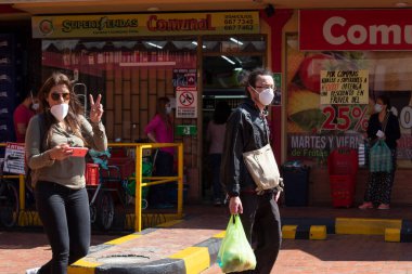 Yüzü maskeli genç bir çift COVID19 küresel salgını nedeniyle zorunlu karantinaya alınarak market alışverişi yapıyor.