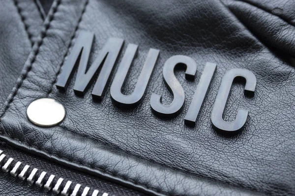 一款Music黑色字母在黑色摩托车皮夹克上的缩写 音乐爱好者和时尚观念风格 — 图库照片